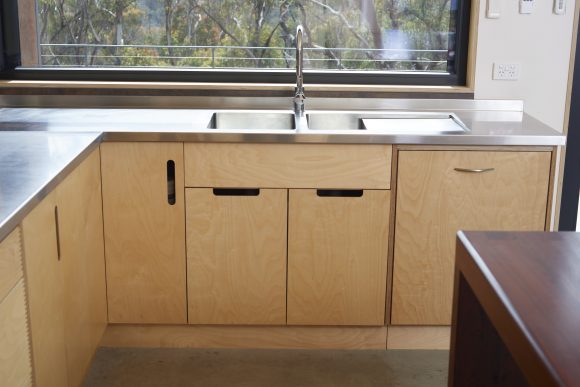 Custom stainlesss steel sink with plywood cabinetry